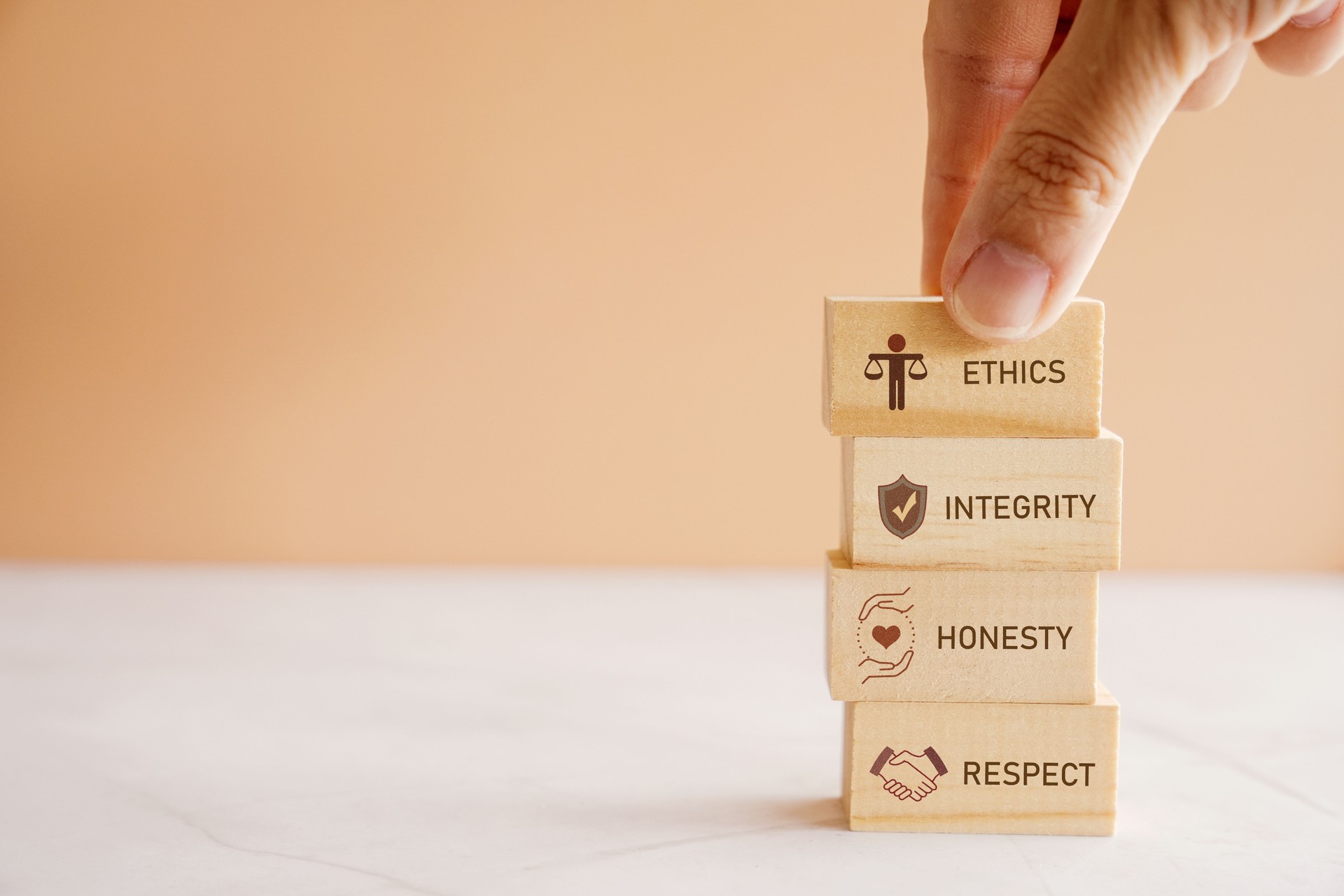 Hand holding wooden block with code of conduct concept, ethics, integrity, honesty, respect.